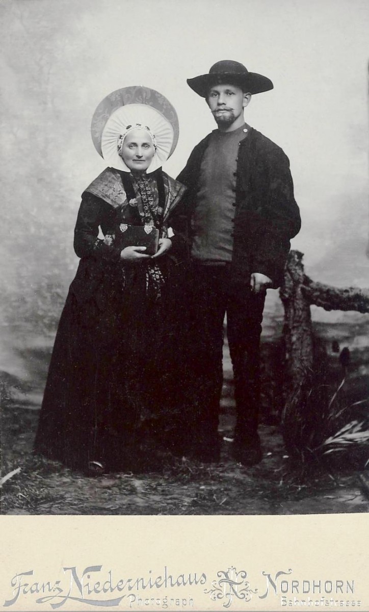 Echtpaar in Breklenkamper dracht. Deze foto is omstreeks 1870-1880 gemaakt door fotograaf Franz Niederniehaus uit Nordhorn. Op de achterkant staat in potlood aangetekend: Costuum Brekelenkamp Overijssel. Het afgebeelde echtpaar vestigde zich op de Frensdorfer Haar. Waarschijnlijk gaat het om een trouwfoto, gelet op het feit dat de vrouw een pronkmuts draagt voor uit de rouw, in combinatie met een zonhoed en een effen batisten muts over een stevige katoenen ondermuts. 